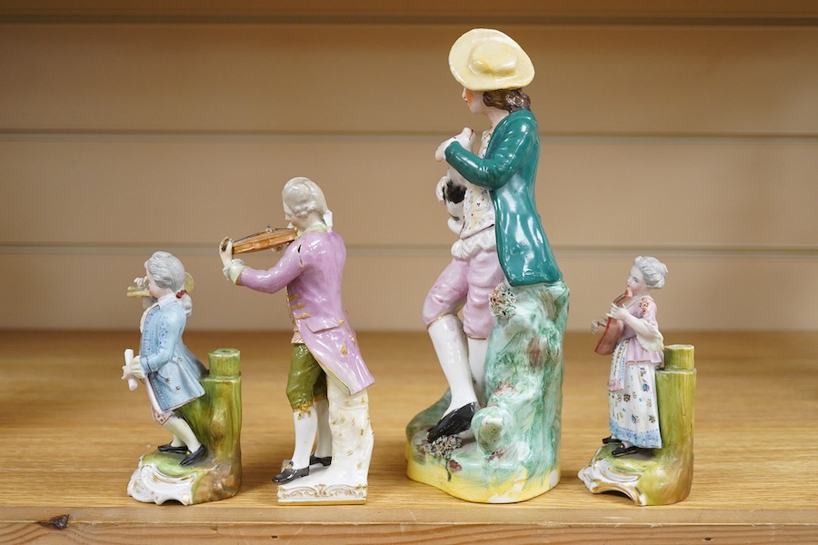 A mid 19th century Staffordshire figure wearing a green jacket, a Berlin KPM figure of a violinist and two coloured biscuit musicians, tallest 23cm. Condition - fair to good